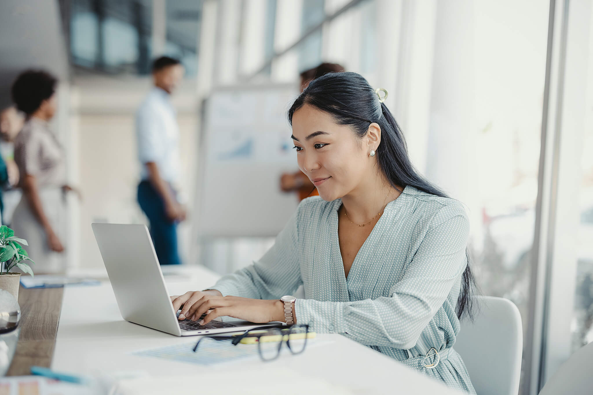 Woman writing job ads for rental business on laptop