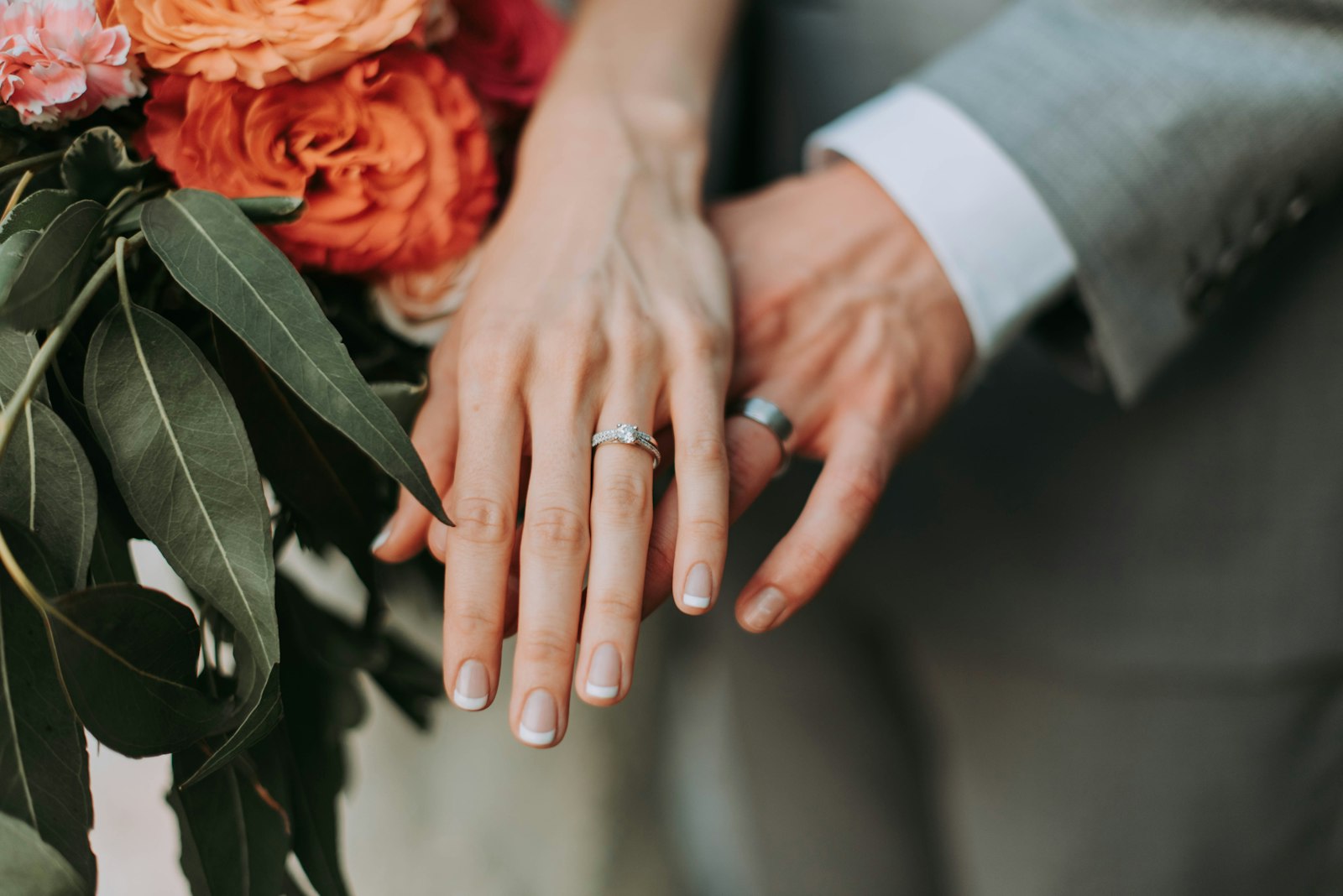 Newly engaged couple holding hands with wedding rings