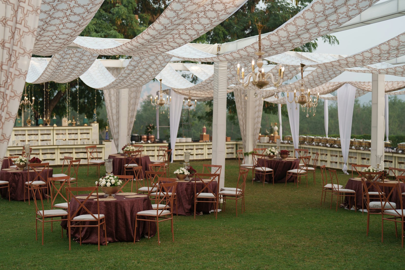 Tented outdoor wedding reception with draped canopy and tables, showing when to ask rental clients for a review after the event