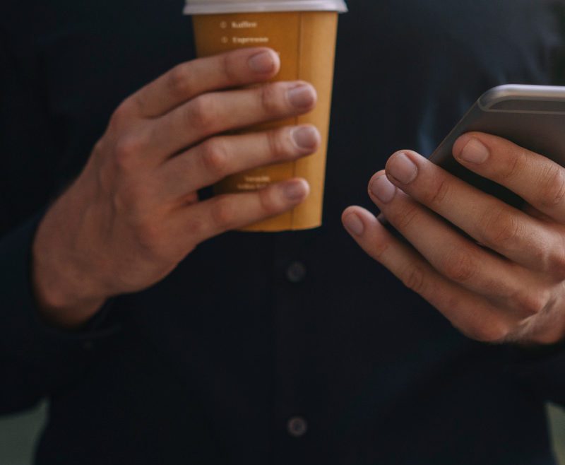 Person Holding Coffee and Phone